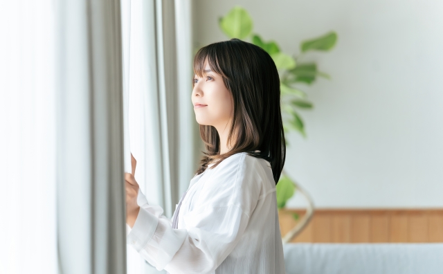 カーテンを開ける女性